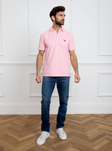 Man wearing pale pink polo shirt in 100% cotton with Newmarket 875 horse logo embroidered on the front.